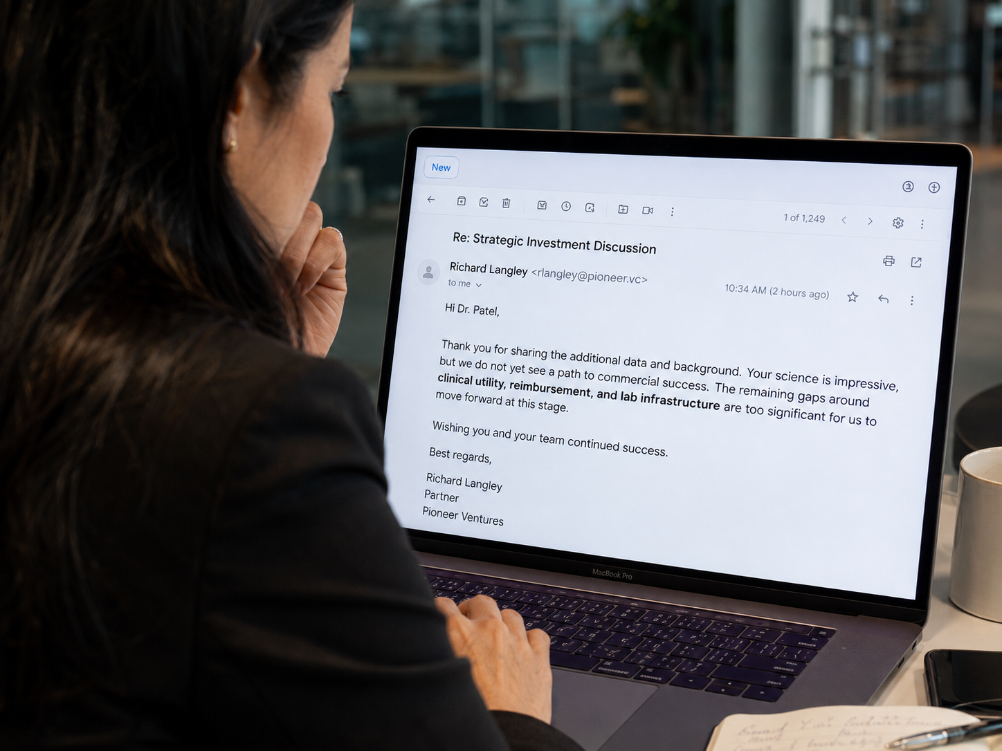 A biotech founder reading an investor email passing on the deal, citing gaps in clinical utility, reimbursement, and lab infrastructure despite strong science
